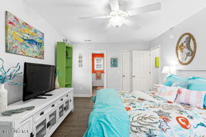 124 NE 15th St, Oak Island, NC 28465 - bedroom with baseboards, ceiling fan, and dark wood-type flooring