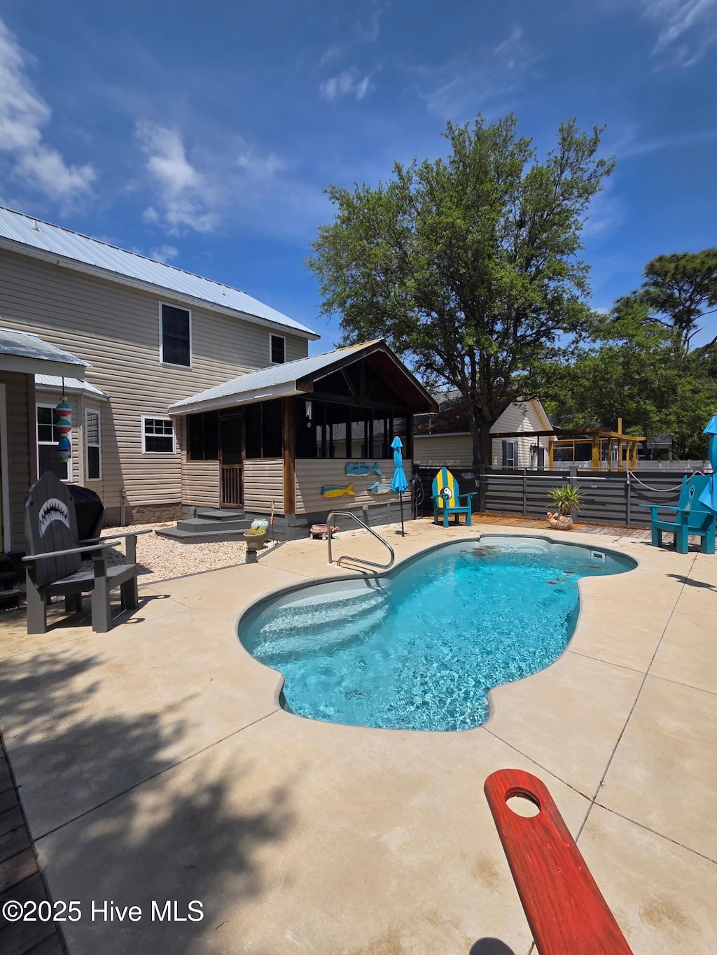 view of swimming pool featuring a sunroom, a patio area, fence, and a fenced in pool