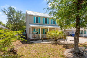 124 NE 15th St, Oak Island, NC 28465 - view of front facade with a porch, metal roof, and a standing seam roof