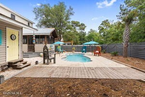 124 NE 15th St, Oak Island, NC 28465 - view of pool with entry steps, a patio area, a fenced in pool, and a fenced backyard