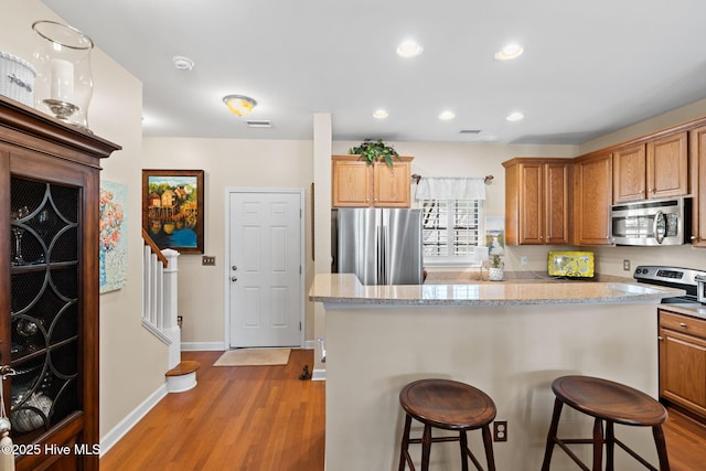 7610 High Market St Unit 3, Sunset Beach, NC 28468 - kitchen with stainless steel appliances, light wood-style floors, a breakfast bar, a center island, and recessed lighting