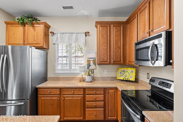 7610 High Market St Unit 3, Sunset Beach, NC 28468 - kitchen with stainless steel appliances, brown cabinets, and light stone counters