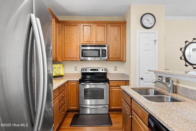 7610 High Market St Unit 3, Sunset Beach, NC 28468 - kitchen featuring stainless steel appliances, a sink, light stone countertops, brown cabinetry, and ornamental molding