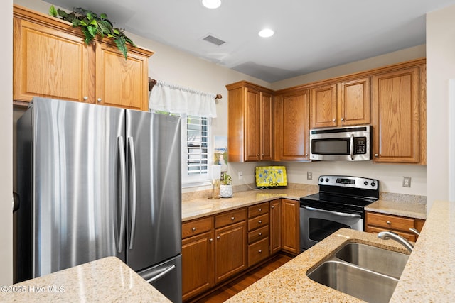 7610 High Market St Unit 3, Sunset Beach, NC 28468 - kitchen featuring appliances with stainless steel finishes, a sink, dark wood finished floors, recessed lighting, and light stone counters
