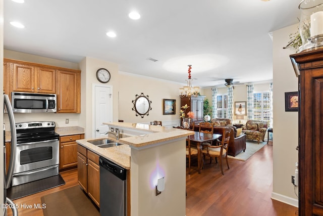 7610 High Market St Unit 3, Sunset Beach, NC 28468 - kitchen with stainless steel appliances, a sink, a ceiling fan, dark wood finished floors, and open floor plan