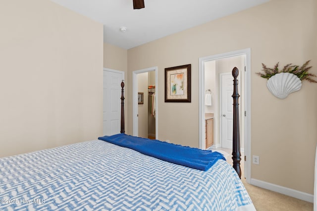 7610 High Market St Unit 3, Sunset Beach, NC 28468 - bedroom featuring a spacious closet, light colored carpet, connected bathroom, baseboards, and a ceiling fan