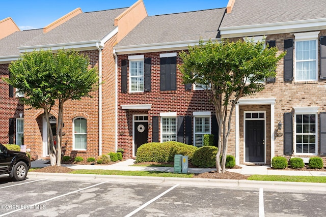 7610 High Market St Unit 3, Sunset Beach, NC 28468 - view of property with brick siding, uncovered parking, and roof with shingles