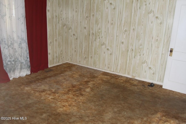 spare room featuring baseboards and carpet flooring