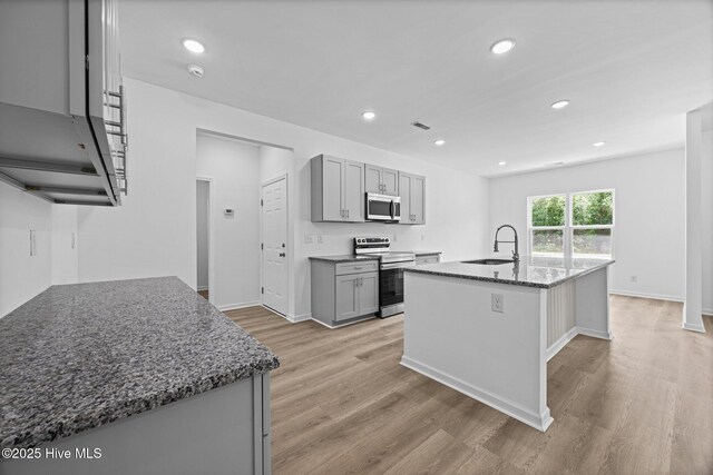 2594 Fountaintown Rd, Chinquapin, NC 28521 - kitchen with stainless steel appliances, white cabinetry, light stone counters, light wood finished floors, and recessed lighting