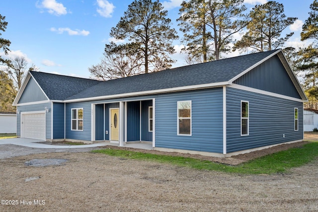 ranch-style house featuring a garage and roof with shingles