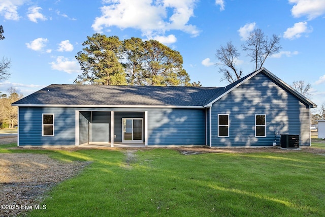 back of property featuring a lawn, roof with shingles, a patio area, and central air condition unit