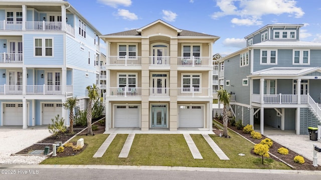 raised beach house featuring a front lawn, driveway, an attached garage, and stucco siding