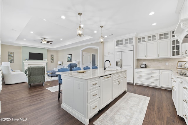 kitchen with recessed lighting, arched walkways, a ceiling fan, dark wood-type flooring, and a tray ceiling