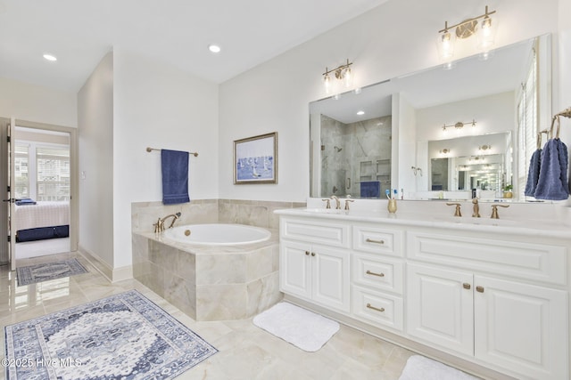 ensuite bathroom with connected bathroom, a shower stall, double vanity, a bath, and a sink