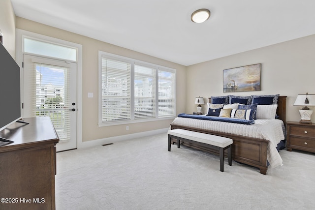 bedroom featuring multiple windows, access to outside, and light carpet
