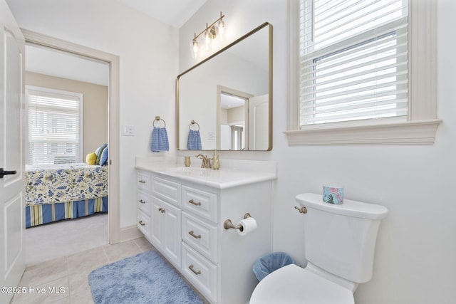 ensuite bathroom featuring toilet, tile patterned floors, vanity, and ensuite bath