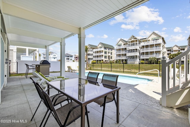 view of patio / terrace featuring fence, outdoor dining space, and a fenced in pool