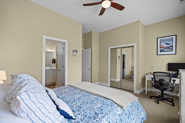 carpeted bedroom with ensuite bathroom, a closet, ceiling fan, and baseboards