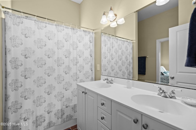 bathroom featuring curtained shower, double vanity, and a sink