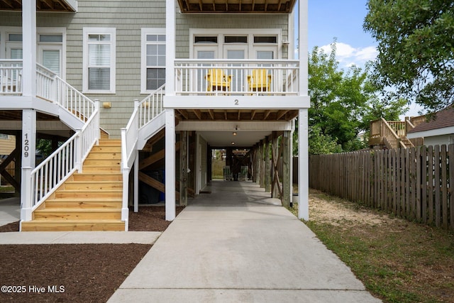 exterior space featuring stairs, a carport, and fence