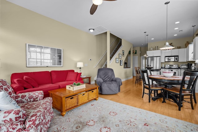 living area with recessed lighting, light wood-type flooring, stairs, a ceiling fan, and visible vents