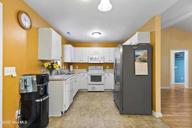 8602 Heirloom Dr NE, Leland, NC 28451 - kitchen featuring baseboards, white appliances, light countertops, a sink, and white cabinetry