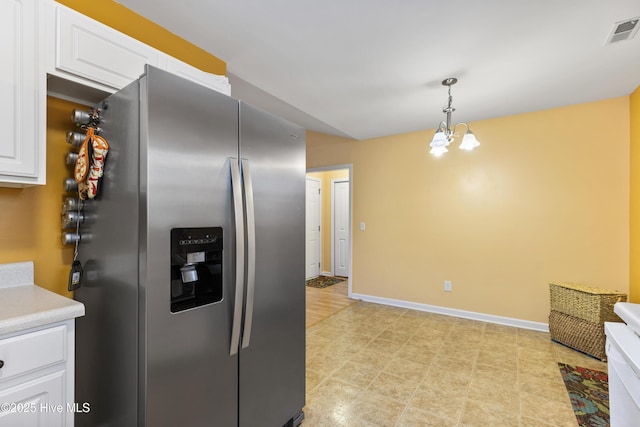 8602 Heirloom Dr NE, Leland, NC 28451 - kitchen featuring white cabinets, visible vents, light countertops, an inviting chandelier, and stainless steel refrigerator with ice dispenser