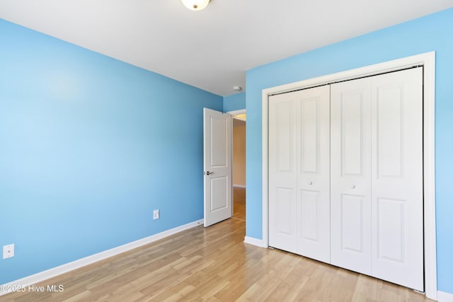 8602 Heirloom Dr NE, Leland, NC 28451 - unfurnished bedroom featuring baseboards, light wood-type flooring, and a closet