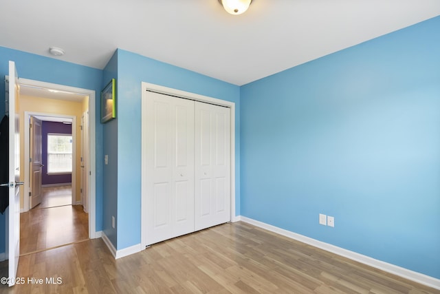 8602 Heirloom Dr NE, Leland, NC 28451 - unfurnished bedroom featuring wood finished floors, a closet, and baseboards