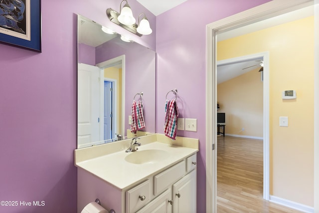 8602 Heirloom Dr NE, Leland, NC 28451 - bathroom with lofted ceiling, wood finished floors, vanity, and baseboards