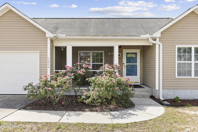 8602 Heirloom Dr NE, Leland, NC 28451 - property entrance with covered porch, a shingled roof, and a garage