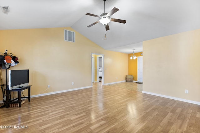 8602 Heirloom Dr NE, Leland, NC 28451 - unfurnished living room featuring visible vents, ceiling fan with notable chandelier, light wood-style flooring, and high vaulted ceiling