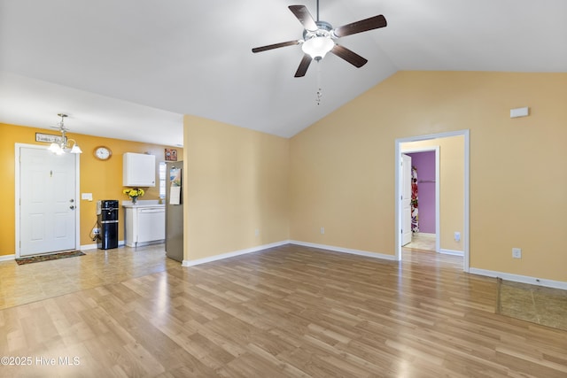 8602 Heirloom Dr NE, Leland, NC 28451 - unfurnished living room with lofted ceiling, light wood-type flooring, baseboards, and ceiling fan with notable chandelier