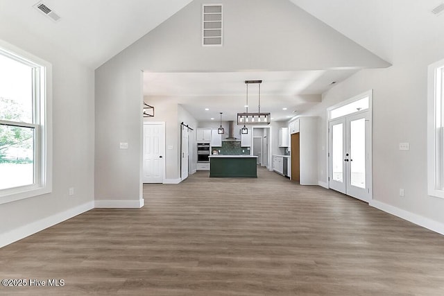 1104 Soundside Rd, Edenton, NC 27932 - unfurnished living room with baseboards, high vaulted ceiling, and visible vents