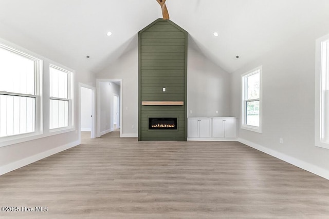 1104 Soundside Rd, Edenton, NC 27932 - unfurnished living room featuring baseboards, a fireplace, light wood-type flooring, and high vaulted ceiling