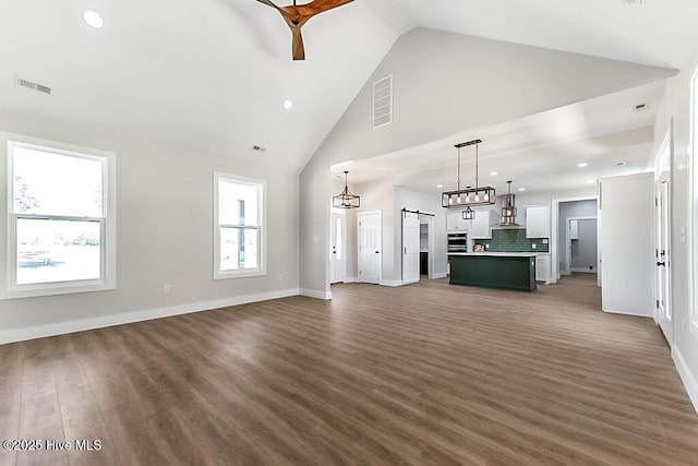 1104 Soundside Rd, Edenton, NC 27932 - unfurnished living room with wood finished floors, visible vents, a barn door, baseboards, and recessed lighting