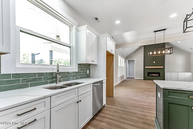 1104 Soundside Rd, Edenton, NC 27932 - kitchen featuring a sink, white cabinetry, backsplash, a large fireplace, and dishwasher