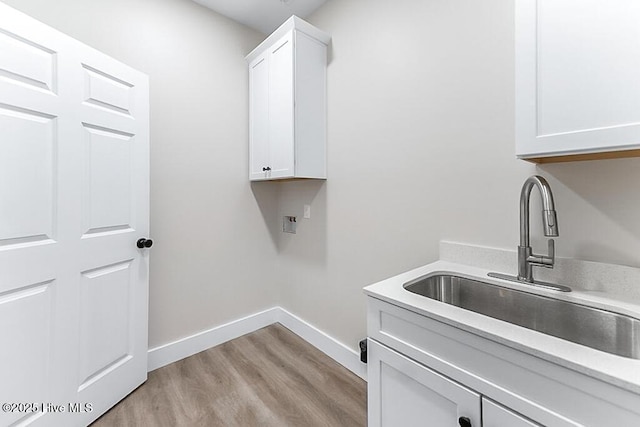 1104 Soundside Rd, Edenton, NC 27932 - washroom with a sink, cabinet space, baseboards, hookup for a washing machine, and light wood-style floors