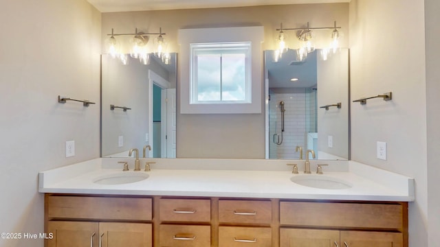 bathroom featuring a stall shower, double vanity, and a sink