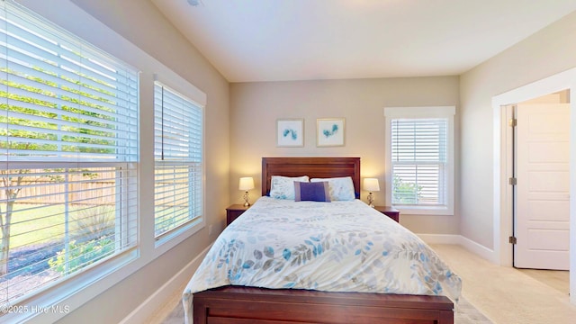 bedroom with light carpet and baseboards