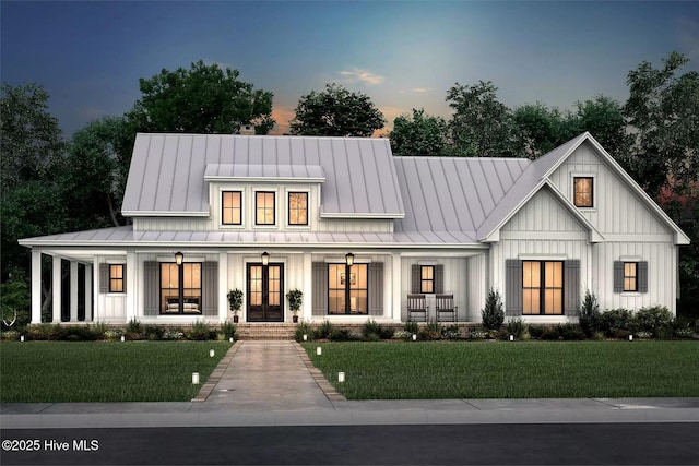 473 White Heron Ct SW, Sunset Beach, NC 28468 - modern farmhouse featuring board and batten siding, a yard, french doors, and a standing seam roof