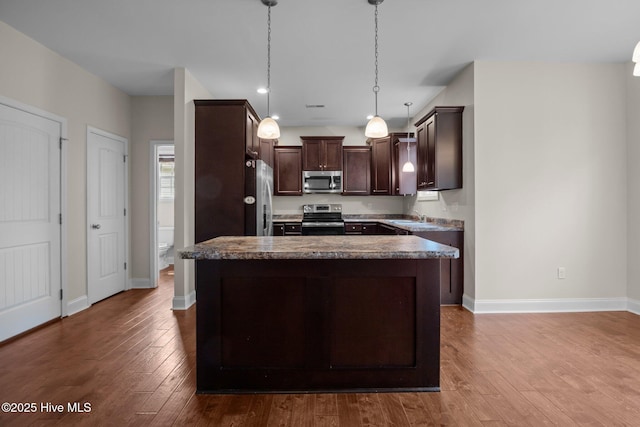 110 Costa Ct, Sneads Ferry, NC 28460 - kitchen with stainless steel appliances, dark brown cabinets, a sink, dark wood-style floors, and pendant lighting