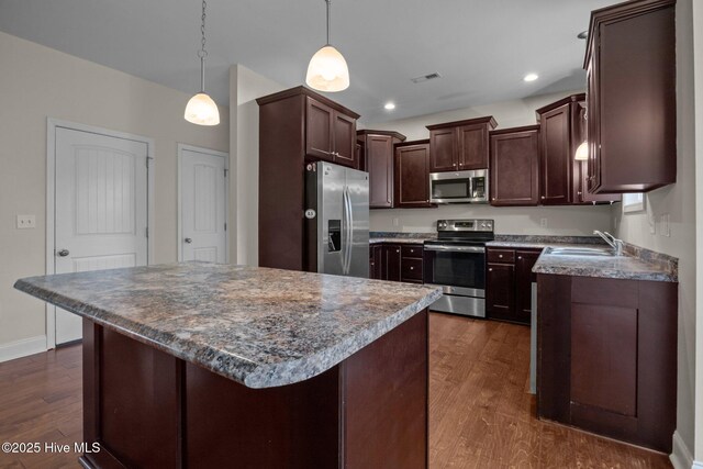 110 Costa Ct, Sneads Ferry, NC 28460 - kitchen featuring appliances with stainless steel finishes, a sink, dark wood-type flooring, dark brown cabinets, and a kitchen island