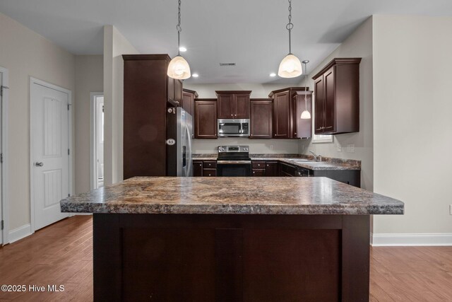 110 Costa Ct, Sneads Ferry, NC 28460 - kitchen with appliances with stainless steel finishes, dark brown cabinetry, baseboards, and dark countertops