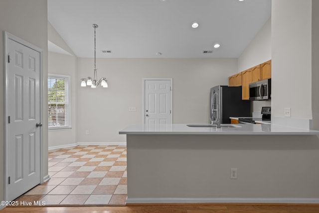 kitchen featuring black electric range oven, stainless steel microwave, freestanding refrigerator, a chandelier, and a peninsula