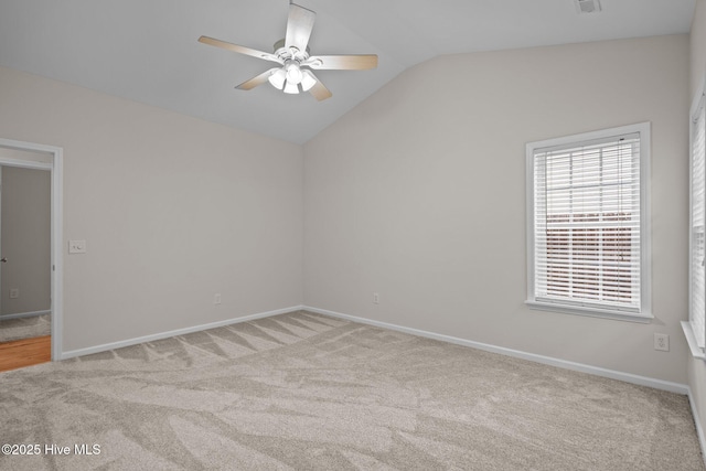 unfurnished room with lofted ceiling, a ceiling fan, carpet floors, and baseboards