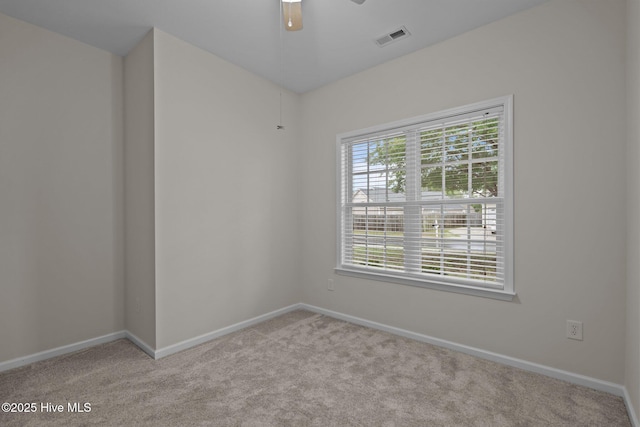 spare room featuring carpet, baseboards, and a ceiling fan