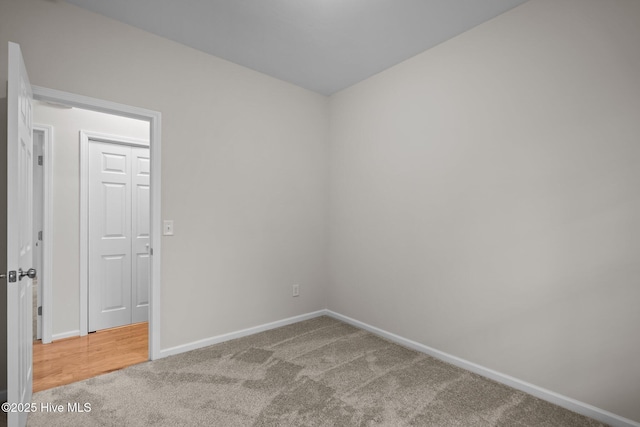 empty room featuring carpet and baseboards