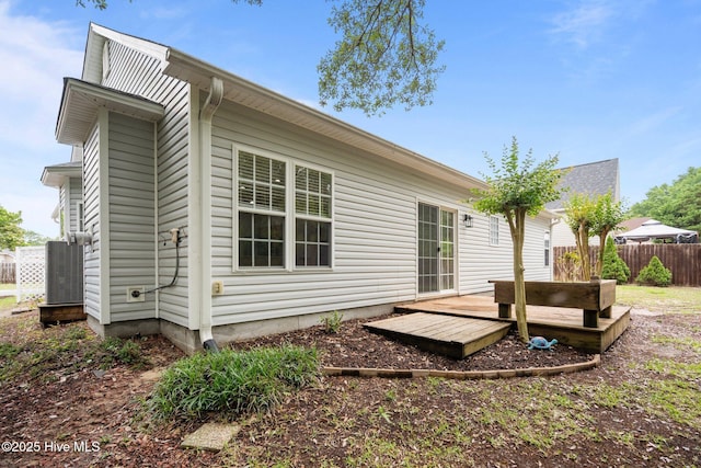back of house with a deck, fence, and central AC