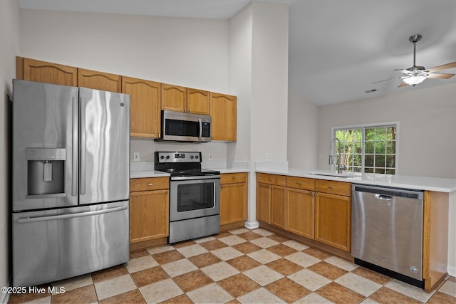 kitchen featuring stainless steel appliances, a sink, light countertops, a peninsula, and ceiling fan